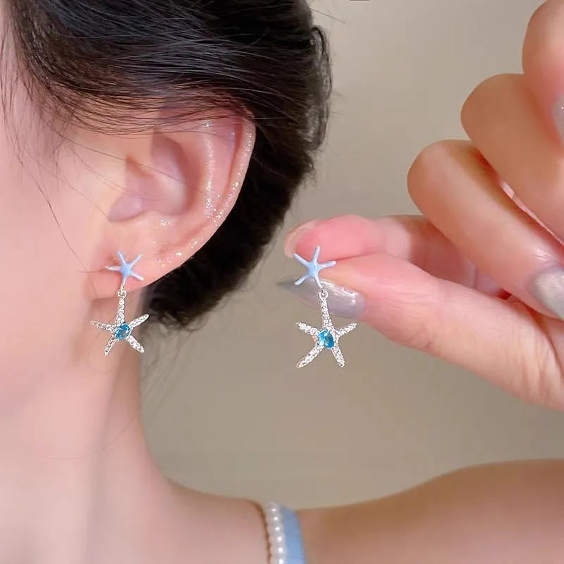 Blue zircon starfish stud earrings in a silver-tone setting with a compact design.