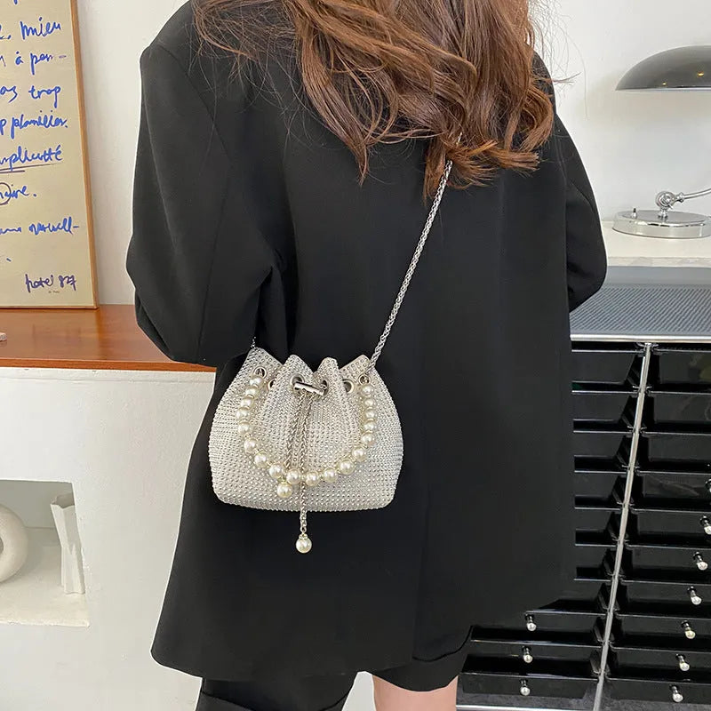 Light diamond PU crossbody shoulder bag with chain strap in bucket shape.