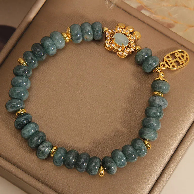 Close-up of a women's bracelet with green emerald jade abacus beads and a silver-toned alloy safety lock clasp.