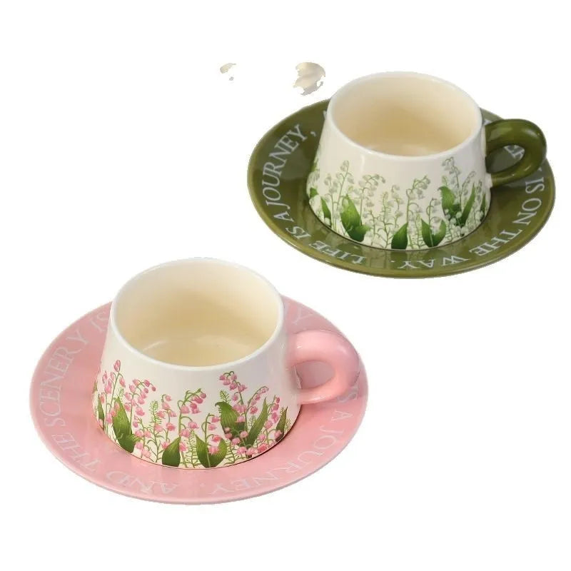 Ceramic coffee cup and saucer set for two people with stirring spoons.