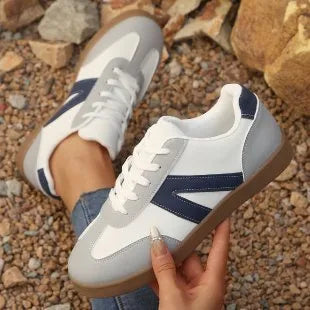 Blue women's low-top hiking shoes with artificial PU upper and rubber sole on a natural background.