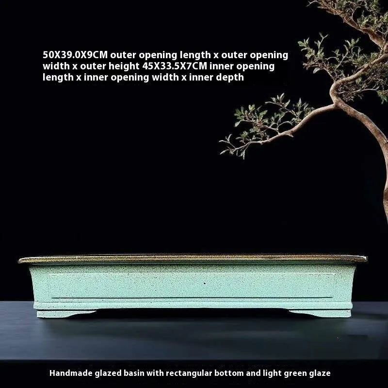 Handmade retro green ceramic bonsai flower pot with crackled glaze on a surface.
