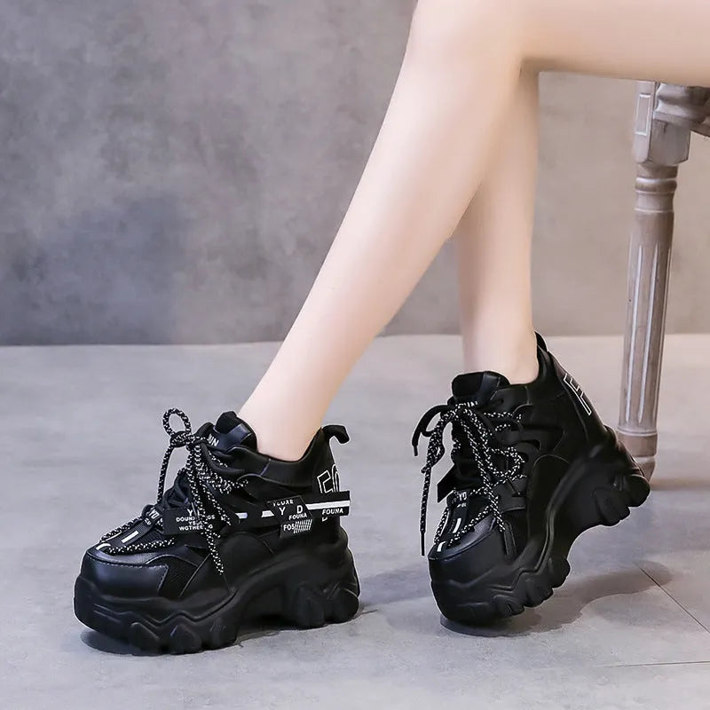 Women's white mesh platform trainers with cross-strap and chunky rubber sole on a neutral background.