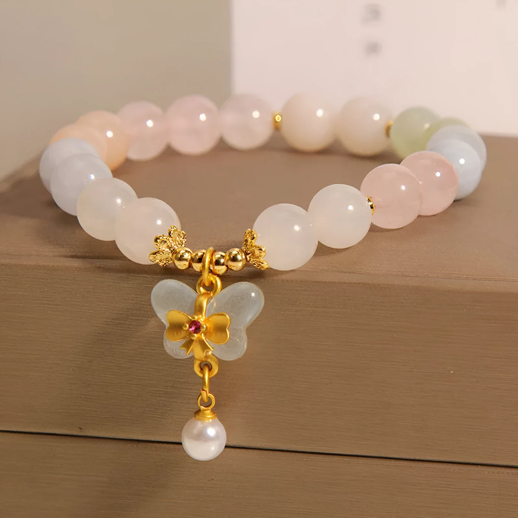 Women's adjustable crystal bracelet with a colourful morganite butterfly pendant on a white background.
