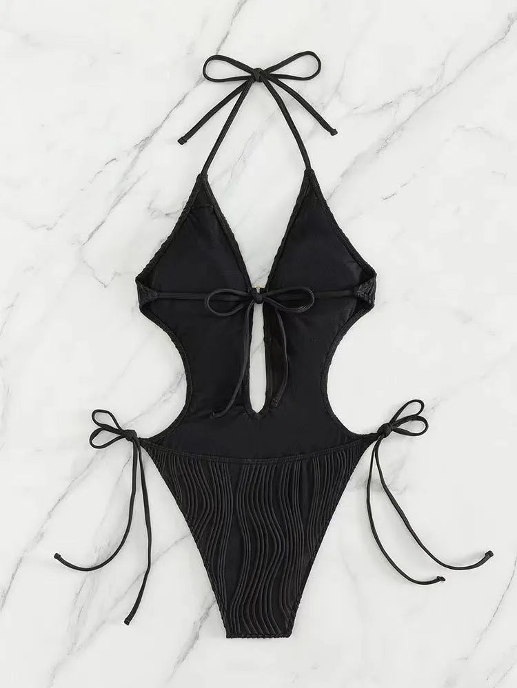 Women's black triangle bikini with lace-up front detail on solid colour background