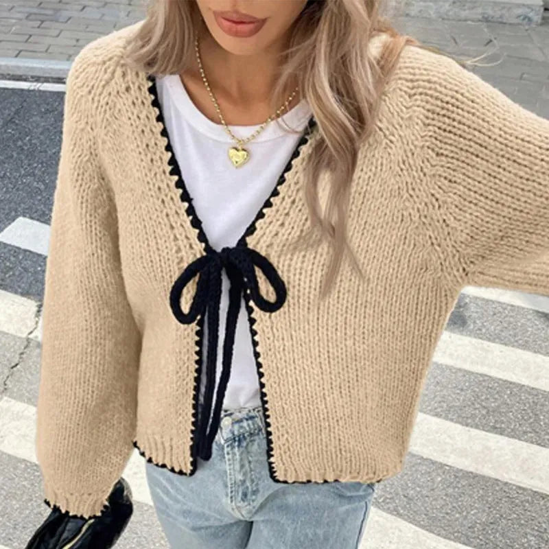 Women's grey lace-up cardigan with crocheted flowers on the front and loose long sleeves.