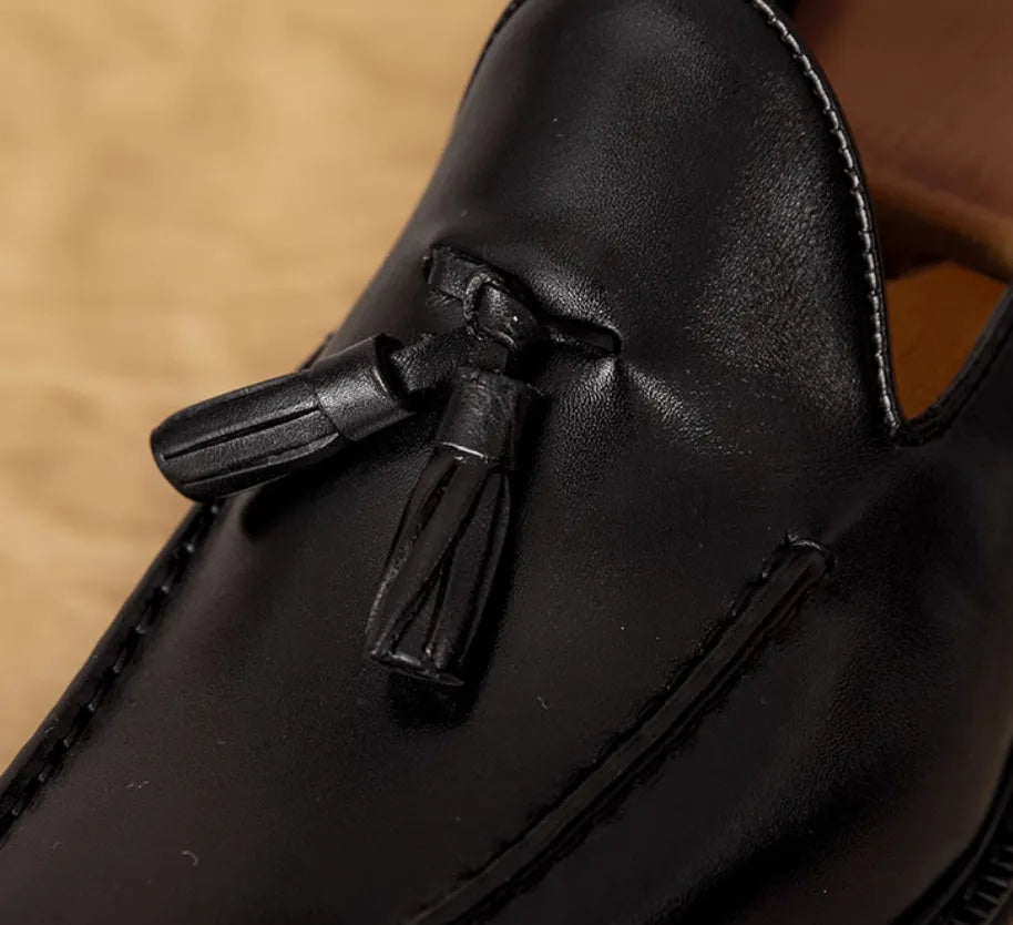 Men's black genuine leather slip-on loafers with fringe detail and rubber sole.