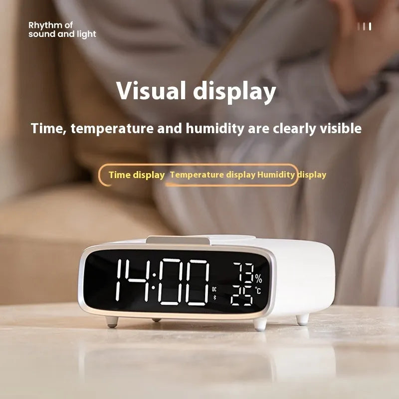 White wireless charging Bluetooth speaker with night light and alarm clock display on desk