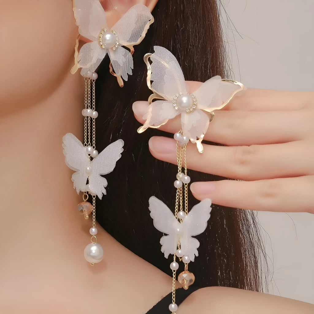 Butterfly shaped white earrings with tassel lace design and pearl rhinestone accents on copper alloy