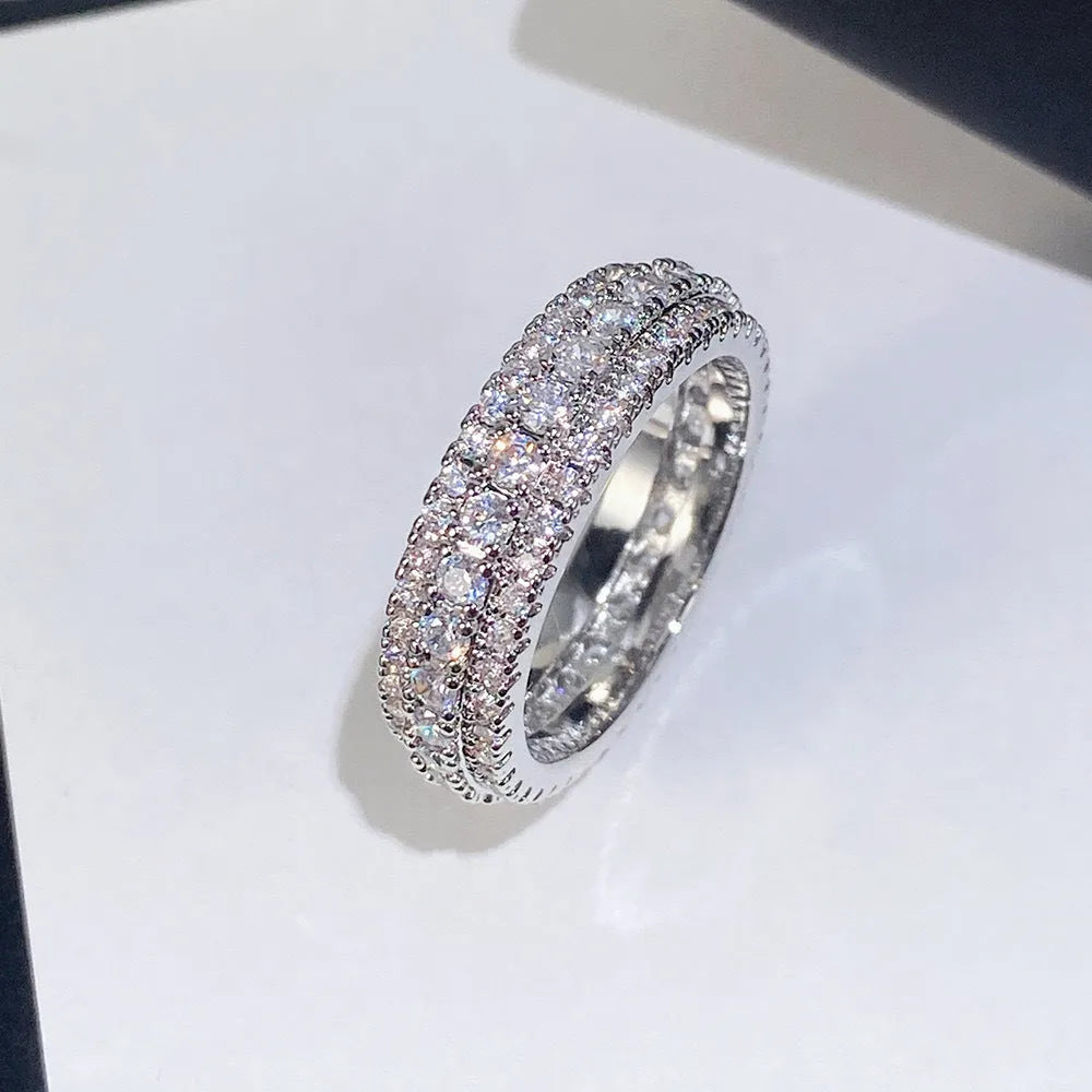 A geometric triangle ring with a zircon inlay, shown in a choice of platinum, yellow gold, or white and black colour.