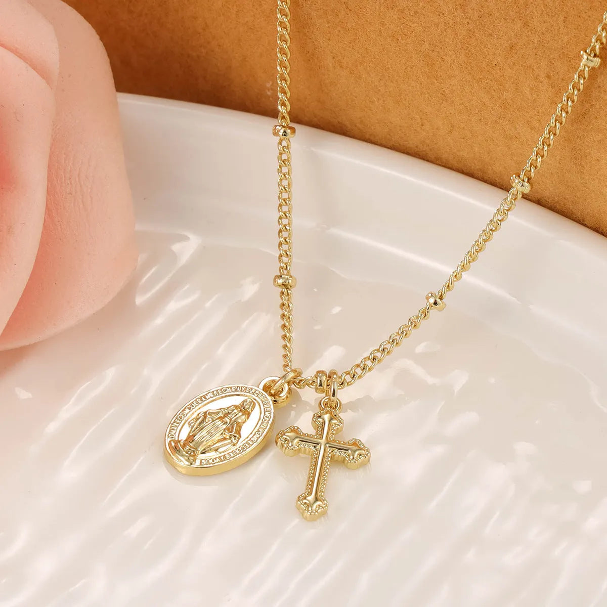 Gold geometric cross necklace with Virgin Mary ornament on chain
