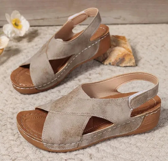 Women's brown roman platform sandals with a skirt detail and velcro strap fastening on a white background