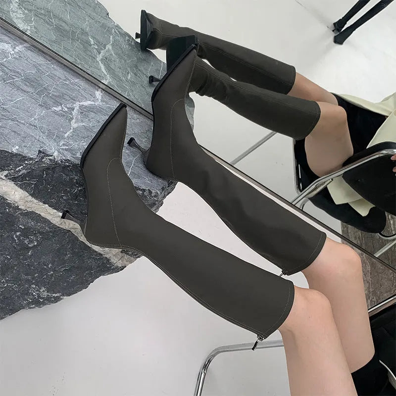 Black pointed toe women's below knee boots with stiletto heel and back zipper.