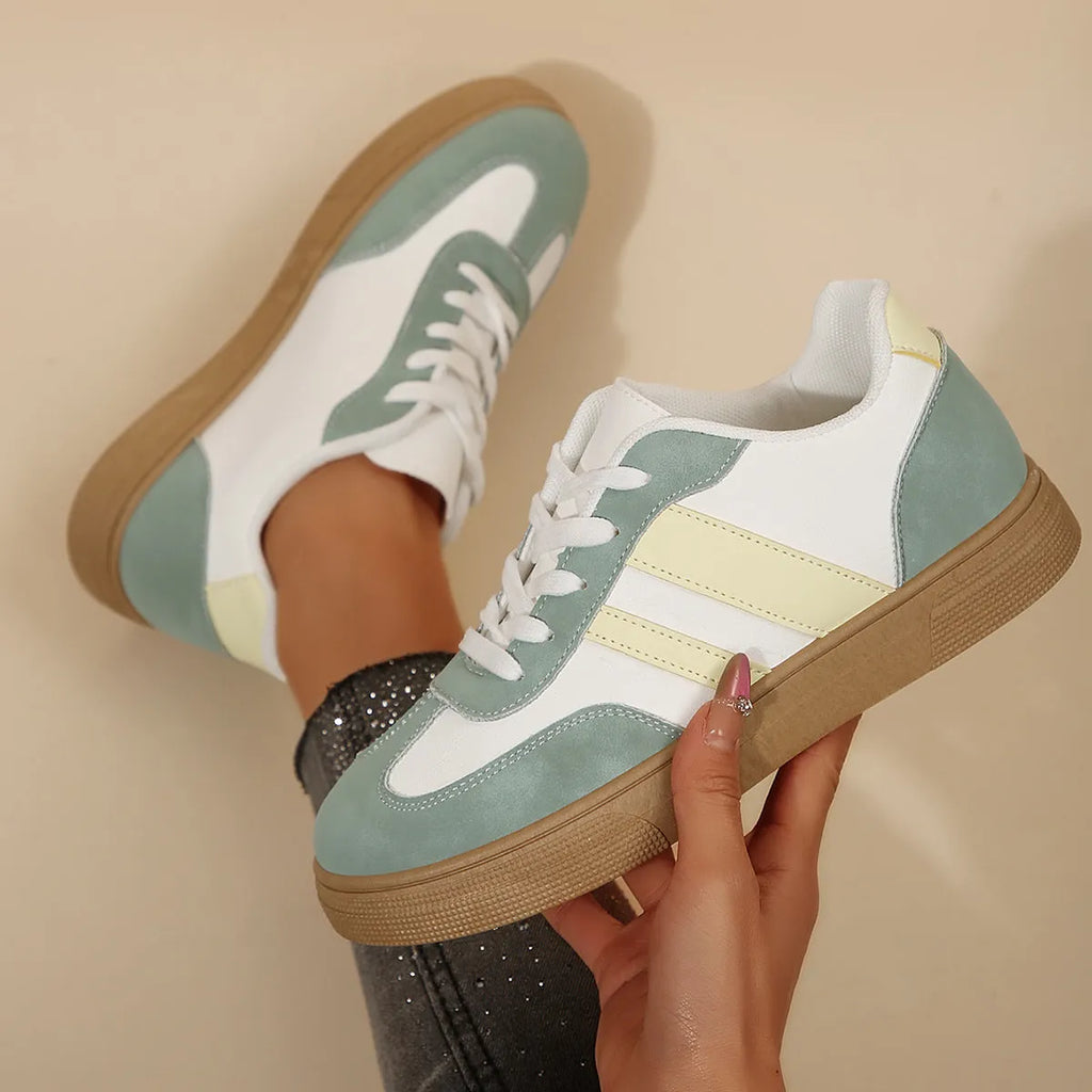 Green retro women's low-top pumps with cross straps, round toe, and flat rubber sole on a white background.