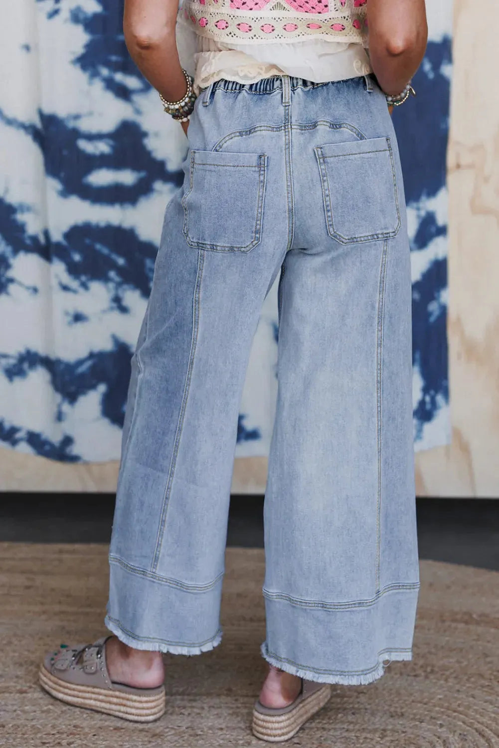 Beau blue wide leg women's denim trousers with a drawstring waist and raw hem detailing.