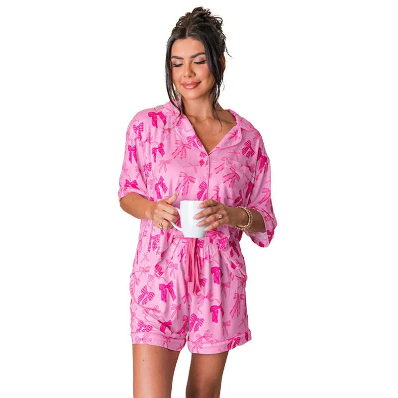 Pink women's pajama set with bow print pattern on thin polyester fabric