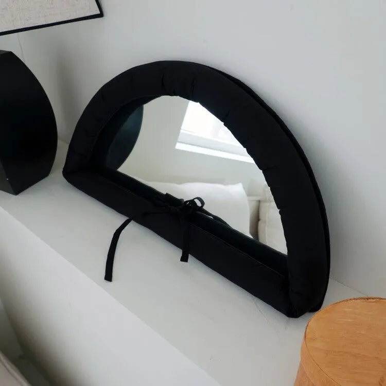 White cotton-filled PVC fabric mirror hanging on wall measuring 23x40x5cm