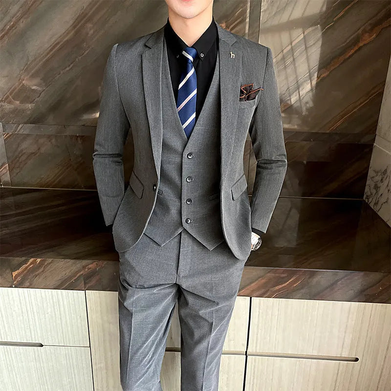 Men's slim fit black business suit jacket and trousers on a hanger.