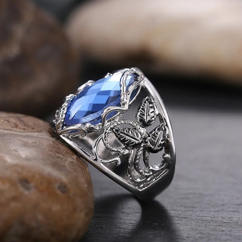 Women's horse eye-shaped blue crystal alloy ring on a hand, showing geometric design.
