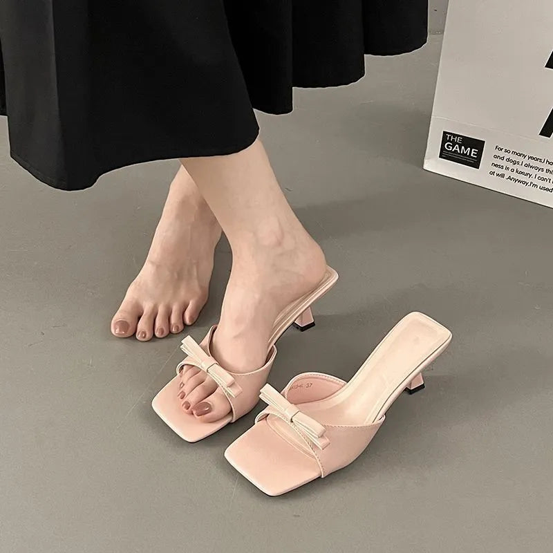 Bow slippers with PU upper and rubber sole in black, white, or pink, sizes 34 to 40
