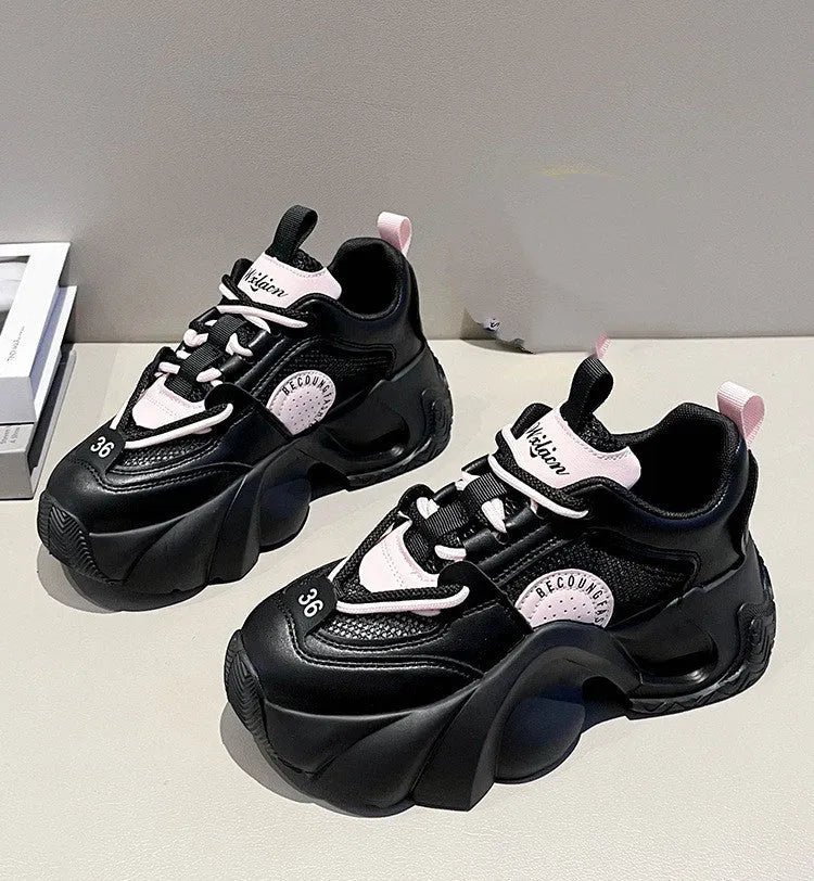 Women's pink platform sneakers with cross straps and a thick sole on a white background.