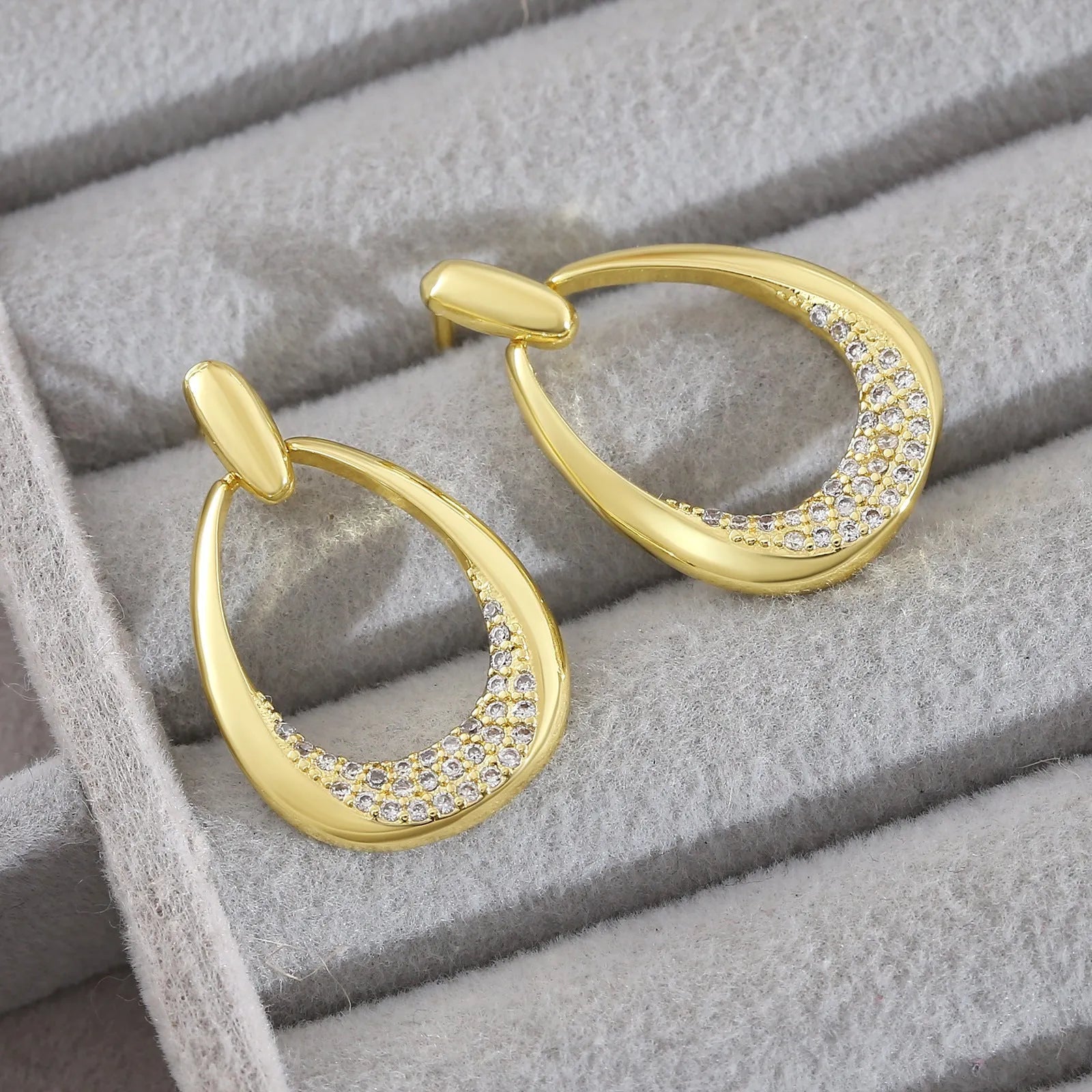 Yellow gold geometric drop-shaped women's earrings with round and oval design elements.
