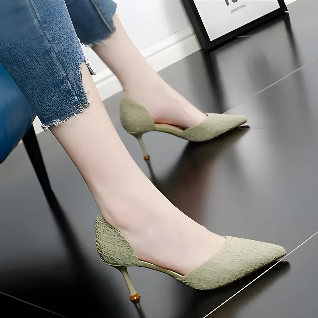 Women's black pointed toe stiletto high heels with a thin heel on a plain background.