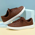 Beige brown platform casual skateboard sneaker with round toe and cross-strap detail on a white background.