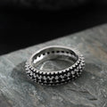 A geometric triangle ring with a zircon inlay, shown in a choice of platinum, yellow gold, or white and black colour.