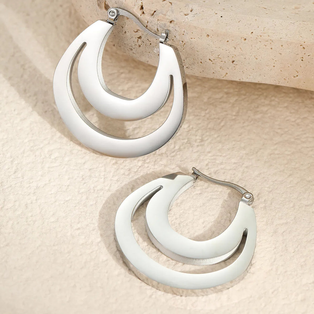 Geometric metallic French earrings with round ring elements in gold and steel finishes