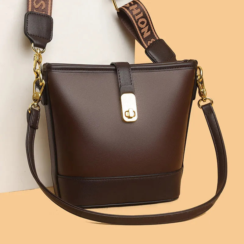 Soft black PU bucket style messenger bag with double shoulder straps, shown open to reveal internal organiser pockets.