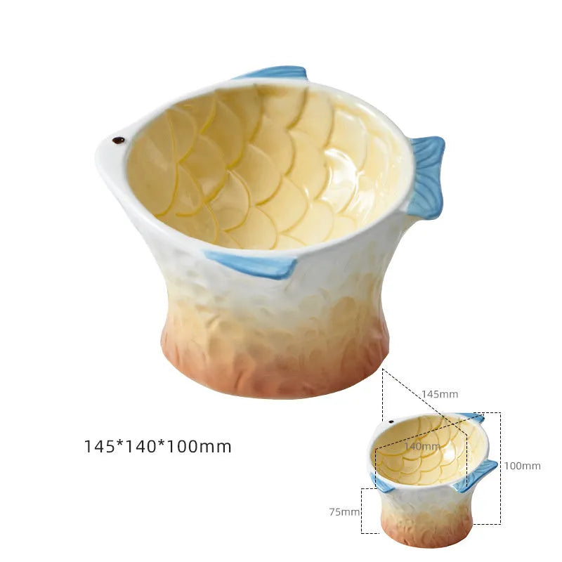 Four coloured fish-shaped ceramic pet bowls with a tilted, elevated design on a plain surface.