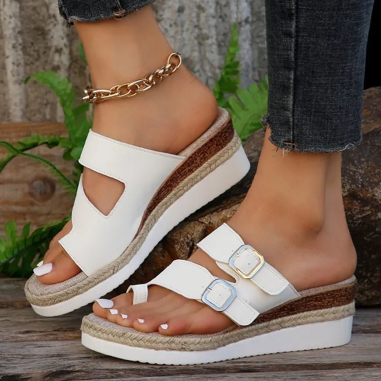 White woven patent leather women's wedge sandals with peep toe and finger-fit design on a neutral background.