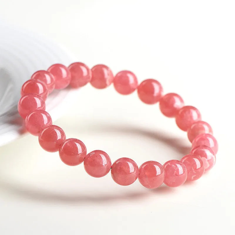 Women's geometric rhodochrosite crystal bracelet with a Longevity Lock design on red beads.
