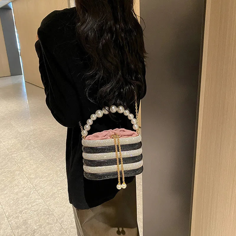 Round women's crossbody bag with beaded pearl details and single shoulder strap in retro styling