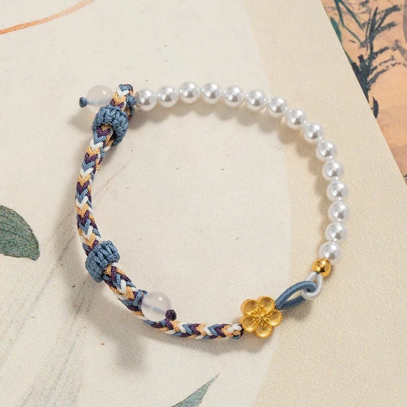 Peach-coloured adjustable cord bracelet with Chinese flower weaving and pearl details.