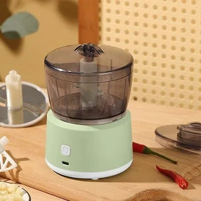 White or light green mini electric meat grinder with transparent cup on anti-slip base