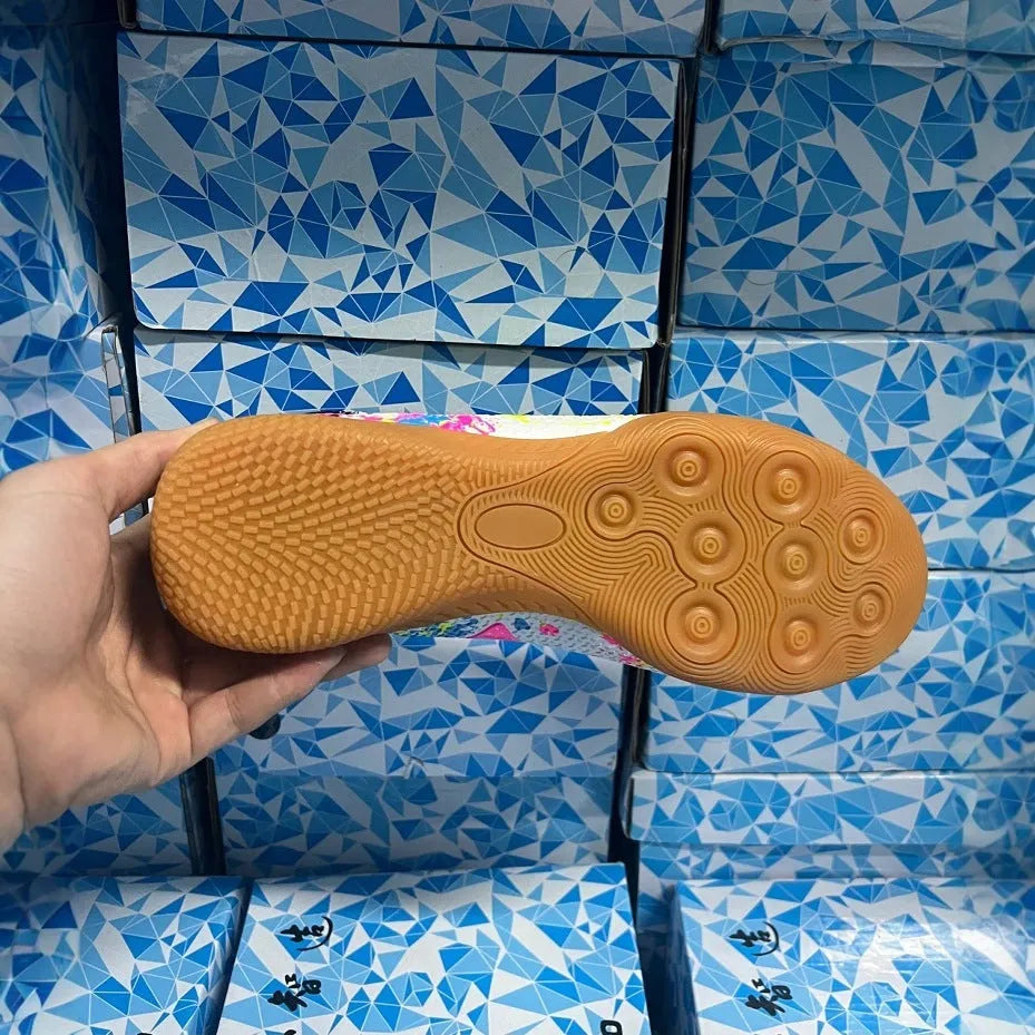 Low-top adult football boots with replaceable screw-in studs on a non-slip rubber sole.