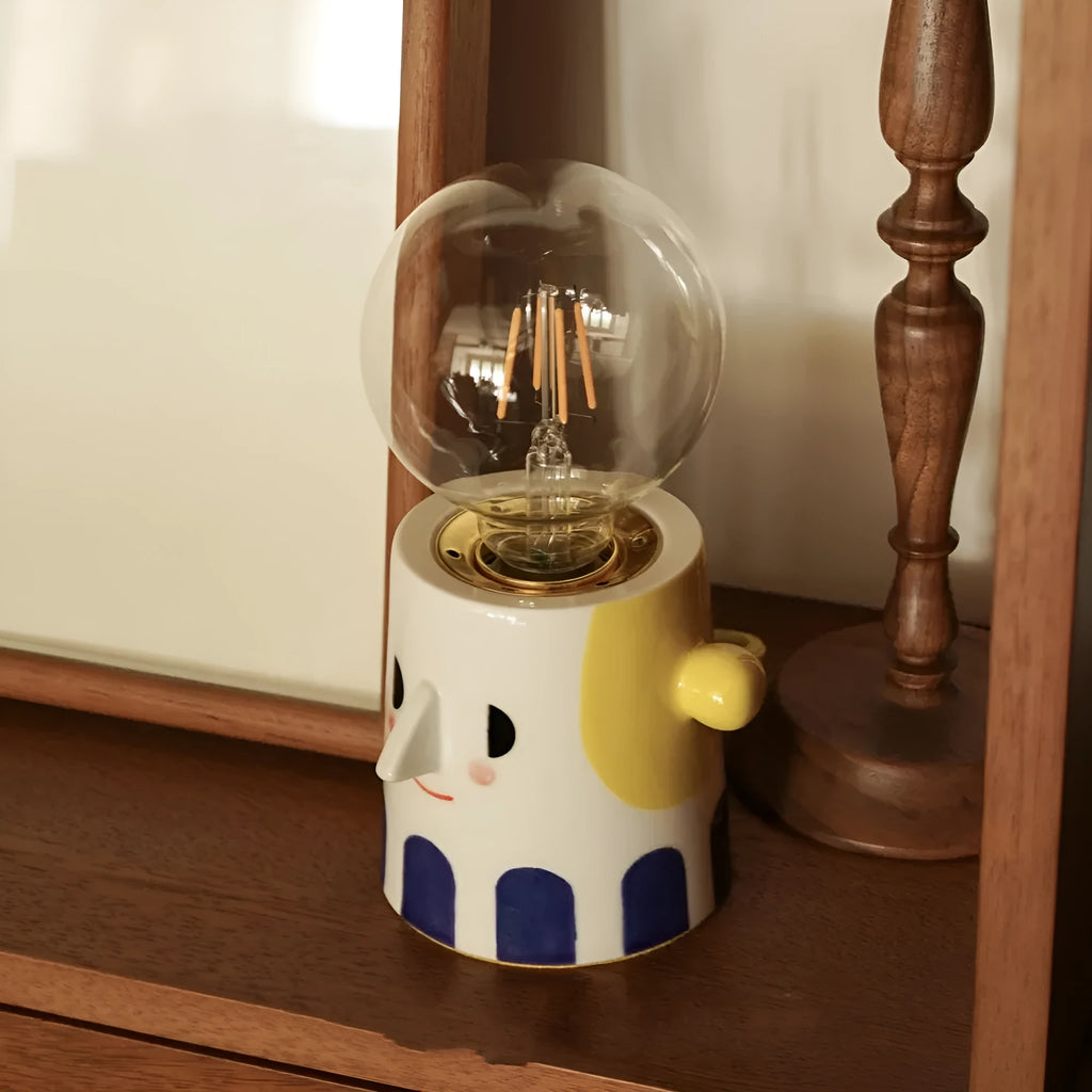 Handmade ceramic table lamp with a spherical ball headlight shape on a stand.