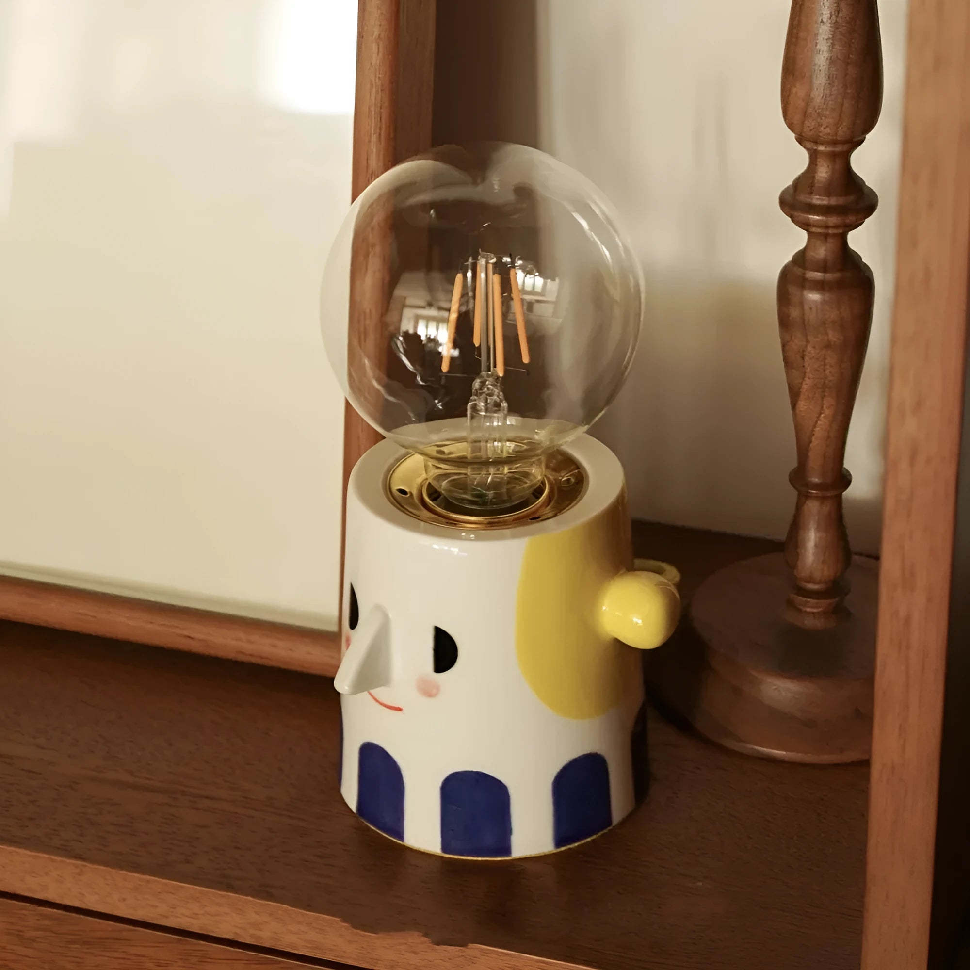 Handmade ceramic table lamp with a spherical ball headlight shape on a stand.