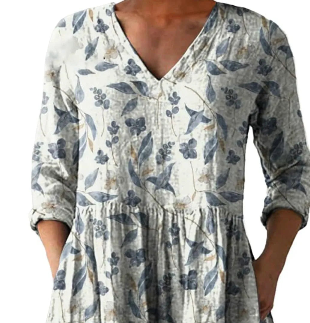 Women's printed loose-fitting dress with wide waist and three-quarter length sleeves.