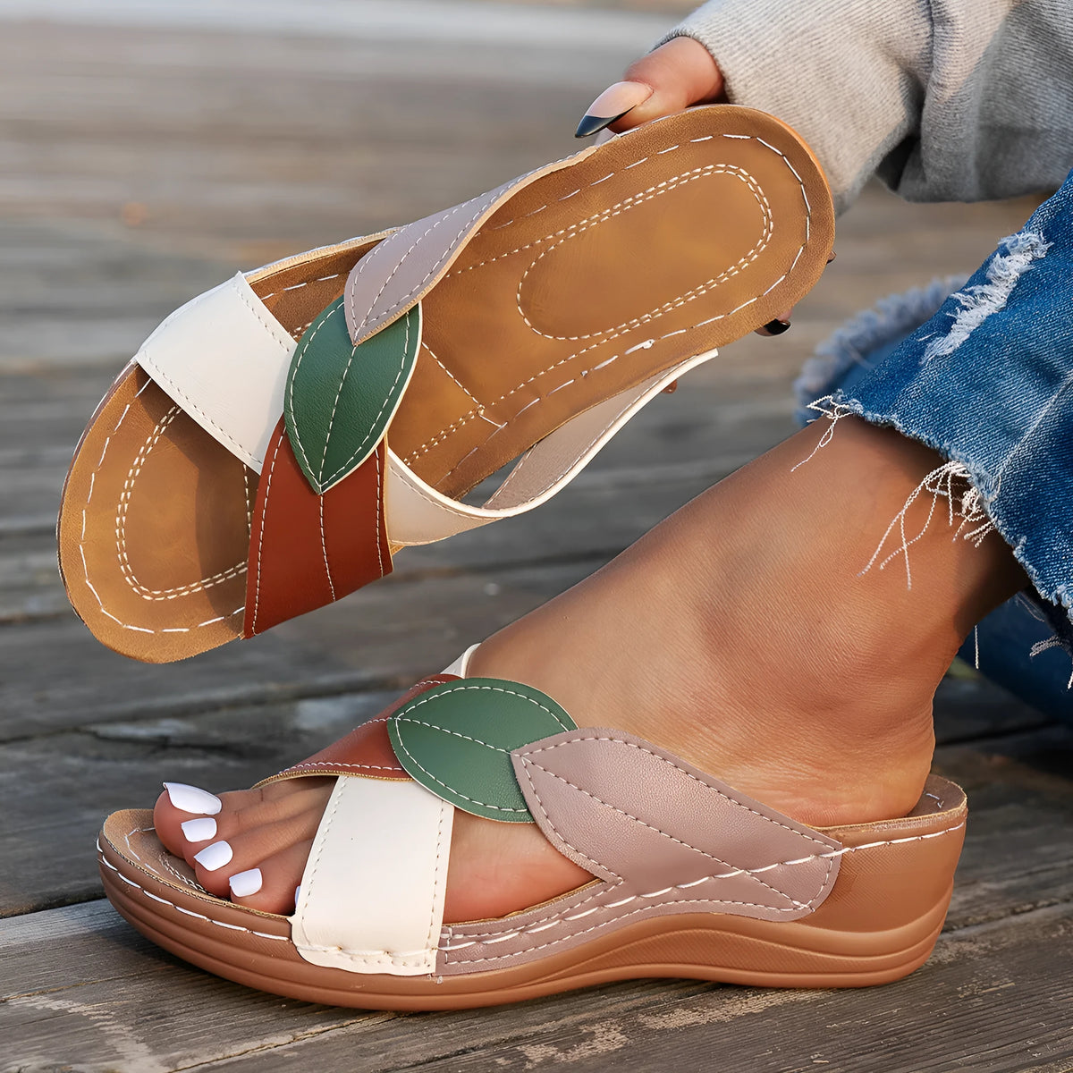 Women's black slippers with thick soles and cross-straps, showing peep-toe design.