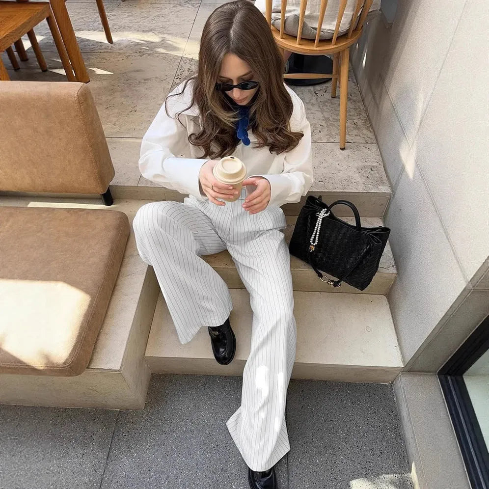 White striped wide-leg women's trousers with a front zip closure on a model