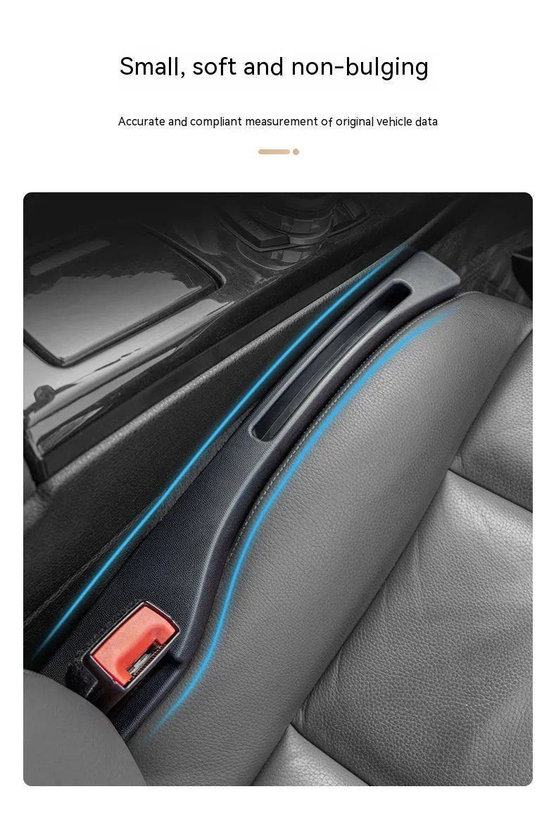 Black plastic car seat gap storage organiser box with a handle, shown inserted between vehicle seats.