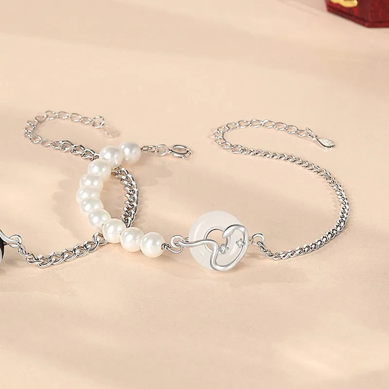 925 sterling silver couple bracelet with snake design and safety buckle on a wrist.