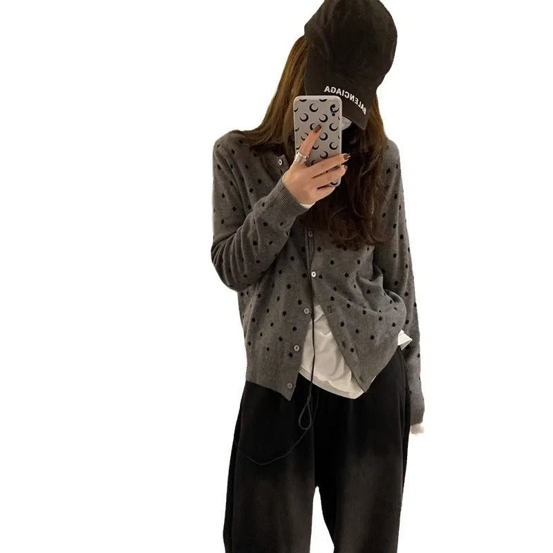 Women's loose-fit gray dot patterned knitted cardigan in black, showcasing crocheted flower detail.