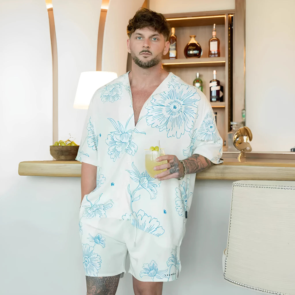 Man wearing a loose-fit, short-sleeve floral print cardigan in a light colour.