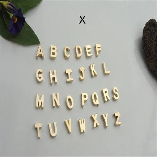 Gold heart shaped alloy pendant with initial letter on white background
