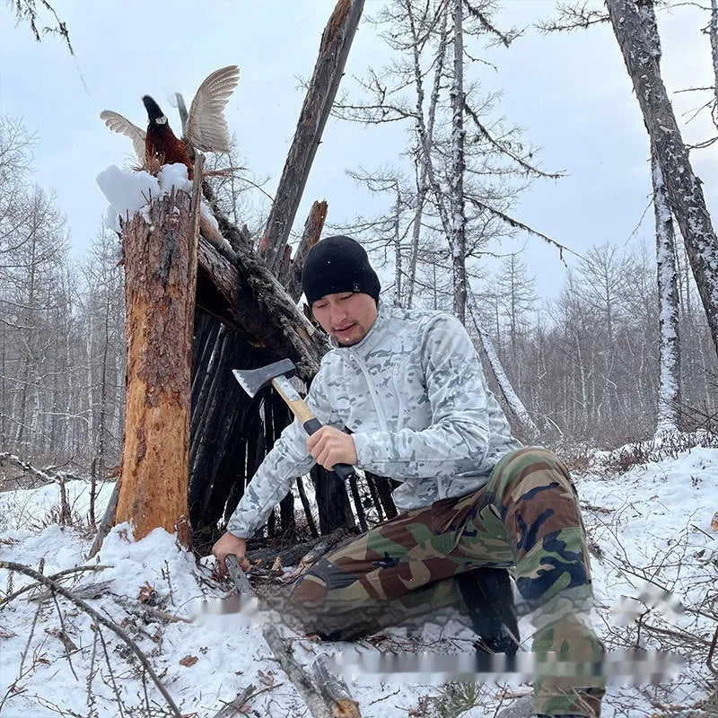 Man wearing a camouflage fleece coat in a woodland setting, showing the Scorpion All Terrain pattern and coat design.
