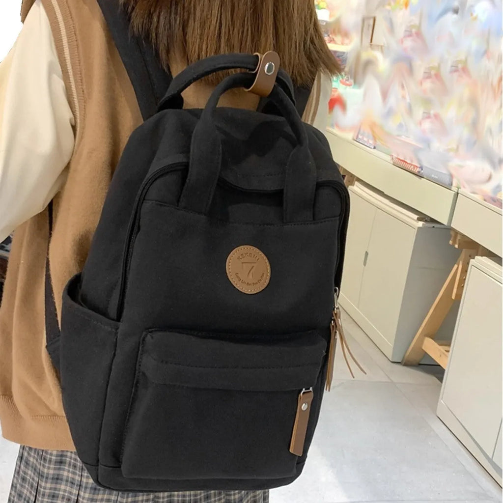 Black Oxford cloth unisex backpack with curved shoulder straps in an urban simplicity style.